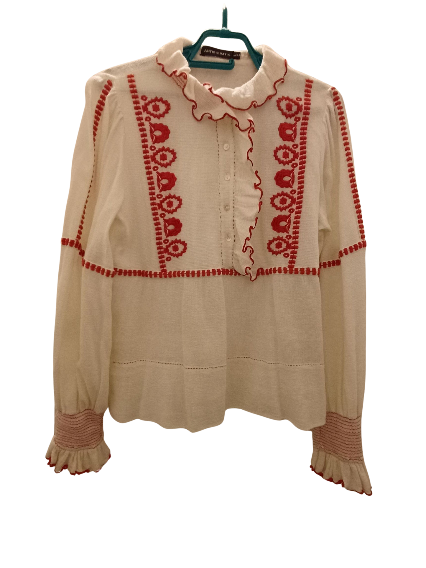 Camisa color crema con bordado rojo.