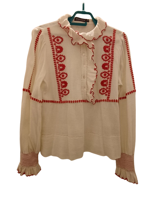 Camisa color crema con bordado rojo.